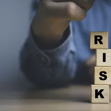 une main tenant un galon à mesurer avec le mot RISK, pour faire référence à l'analyse et la gestion des risques.
