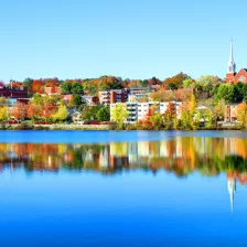 Paysage d'automne de la rivière Magog à Sherbrooke avec maisons, bâtiments et clocher d'église à l'arrière-plan