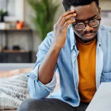 Plan d'un jeune homme en train de faire le point sur ses assurances chez lui